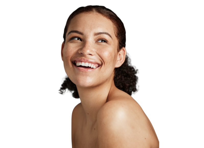 En glad kvinde med fregner og bare skuldre smiler og kigger til siden, hvilket fremhæver hendes sunde og strålende ansigtshud. Hos Cerix tilbyder vi behandlinger som skinboosters og Profhilo til ansigtet for at opnå netop denne naturlige glød og velplejede hud.