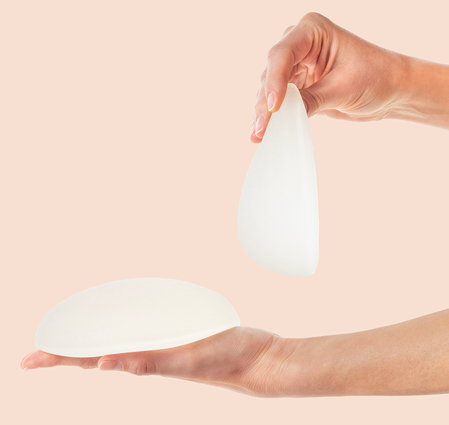 To hænder holder to forskellige brystimplantater mod en lys baggrund. Dette billede illustrerer de typer implantater, som Cerix tilbyder til kvinder, der ønsker en brystforstørrende operation (BFO) for at forbedre brysternes udseende.